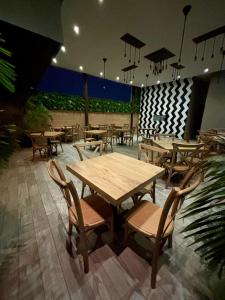 un restaurante con mesas de madera, sillas y luces en Hotel San Miguel Imperial, en Santa Marta