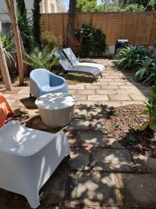a patio with two chairs and a table and chairs at BariMetro Garden in Capurso