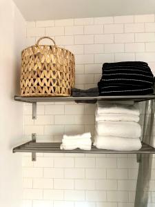 a shelf in a bathroom with towels and a basket at Modern, Bright 2BR Casita in Vibrant Echo Park Silver Lake with Gourmet Kitchen and Unbeatable Proximity to LA Hotspots in Los Angeles