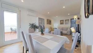 a white dining room with a white table and chairs at Piso grande-Playa a 250m-PortAventura a 15min por autovía in Miami Platja