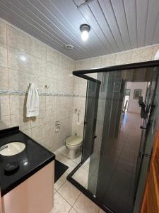 ein Badezimmer mit Dusche, Waschbecken und Toilette in der Unterkunft Casa à Beira-mar de Peroba in Peroba