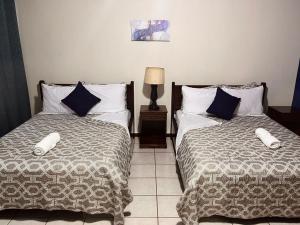two beds sitting next to each other in a bedroom at Hotel Sueños in San Salvador