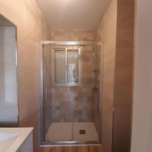 una ducha con puerta de cristal en un baño en Piso cercano al recinto ferial, en Jerez de la Frontera