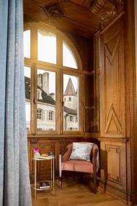 a chair in a room with a large window at Maison 1896 in Beaune
