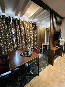 a living room with a table and a curtain at Hotel Sabera in Siliguri