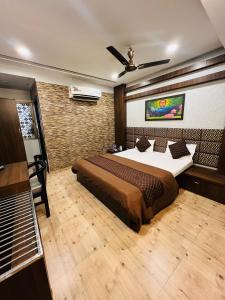 een slaapkamer met een bed en een plafondventilator bij Hotel Sabera in Siliguri