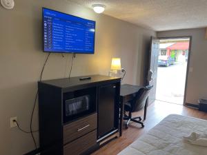 a room with a desk with a monitor on the wall at Super 8 by Wyndham Monroe in Monroe