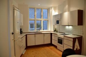a kitchen with white cabinets and white appliances at Rent a Room Copenhagen in Copenhagen