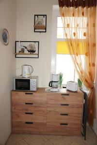 a microwave on top of a wooden dresser with a window at Studio Appartment Heinze in Świnoujście