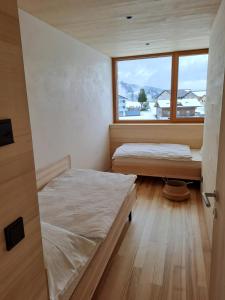 two beds in a room with a window at NEU ausZEIT985 - auszeit mit ausblick in Schwarzenberg