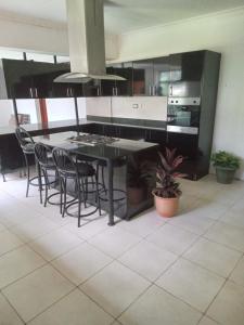 a kitchen with a black table and chairs at J&M Hostel in Moshi