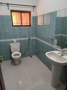 a bathroom with a toilet and a sink at J&M Hostel in Moshi