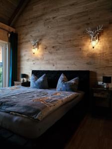 a bedroom with a bed with two deer heads on the wall at Landgasthof Zur Linde in Kronach