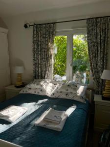 sypialnia z łóżkiem z oknem i ręcznikami w obiekcie Apartament Abi w mieście Vranjica