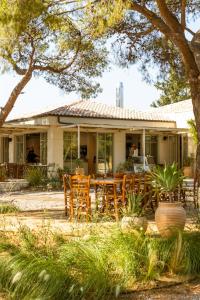 a house with a table and chairs in front of it at Ergon Beach House Nikiti in Nikiti
