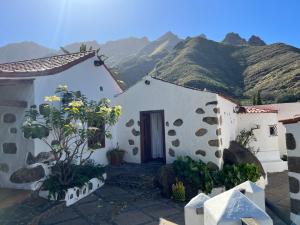 a building with a door with mountains in the background at La Mareta Family Finca in Agaete