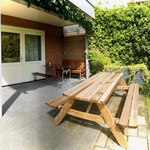 a wooden picnic table sitting on a patio at Rooi Bij de Knoptoren B&B in Sint-Oedenrode +17 photos