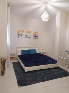 1 dormitorio blanco con 1 cama con manta azul en Room in the centre of La Linea - Habitación en el centro de La Linea en La Línea de la Concepción
