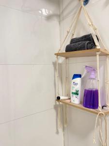 a bathroom shelf with a bottle of soap and a detergent at السحاب in Abha