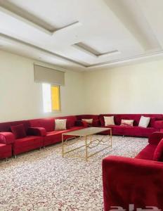 a living room with red couches and a table at السحاب in Abha