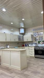 a kitchen with white cabinets and a black stove at السحاب in Abha