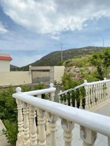 a white railing on a balcony with mountains in the background at السحاب in Abha