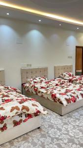 two beds in a room with red and white blankets at السحاب in Abha