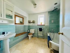 a bathroom with a sink and a toilet and a tub at Bi-Folds/Sonos/Large Open Plan/Central/Parking in Cheddar