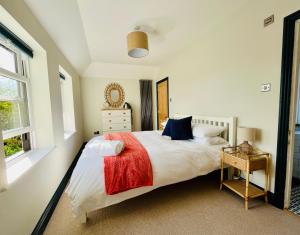 a bedroom with a large bed with a red blanket at Bi-Folds/Sonos/Large Open Plan/Central/Parking in Cheddar