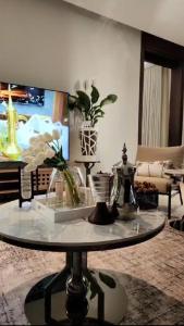 a living room with a glass table with flowers on it at Modern villa فلتي حديثه in Khamis Mushayt
