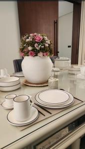 a table with white plates and a vase with flowers at Modern villa فلتي حديثه in Khamis Mushayt