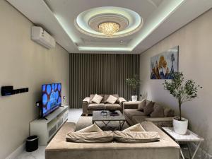 a living room with a couch and a tv at شقة فاخرة ٣ غرف وصالة دخول ذاتي ٩ in Riyadh