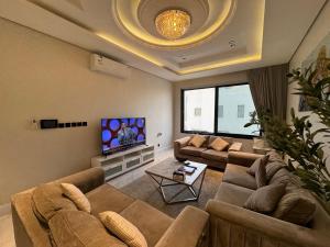 a living room with two couches and a tv at شقة فاخرة ٣ غرف وصالة دخول ذاتي ٩ in Riyadh