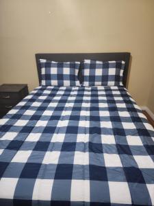 un letto blu e bianco con due cuscini sopra di Cozy bungalow a Calgary
