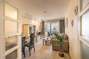 City Center Apartment in Marbella في مربلة: غرفة معيشة مع أريكة وطاولة مع كراسي