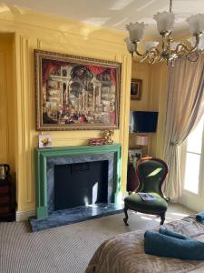 a living room with a fireplace and a chair at Chez Vivienne in Ilkley