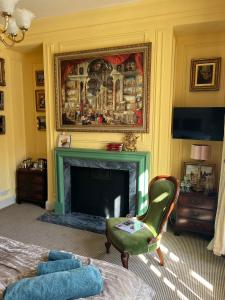 a living room with a fireplace and a green chair at Chez Vivienne in Ilkley