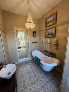 a bathroom with a white tub and a sink at Chez Vivienne in Ilkley