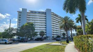 a large white building with cars parked in a parking lot at Bayfront Apartment Breathtaking Views- one bedroom w balcony- living room -Free Parking in Miami Beach