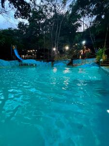 a swimming pool at night with blue water at Hotel Cabañas Club Sierra Limón in Santa Marta