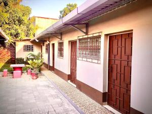 een gebouw met twee bruine deuren en een binnenplaats bij Hostal Notas y Puntadas a 1,2 Kms del Centro Historico de Santa Ana in Santa Ana