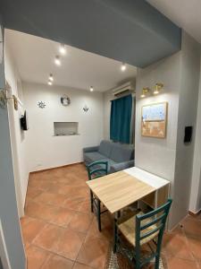 - un salon avec une table et un canapé dans l'établissement Casa TYSANDROS Due passi dal mare, à Giardini Naxos