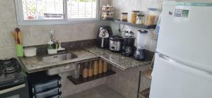 una pequeña cocina con fregadero y nevera. en Espaço do acalanto, en Natal