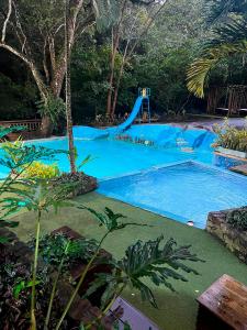 a swimming pool with a slide in a resort at Hotel Cabañas Club Sierra Limón in Santa Marta