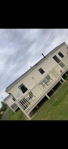 un gran edificio con un porche y una casa en Blue Beach Retreats Ltd, en Mablethorpe