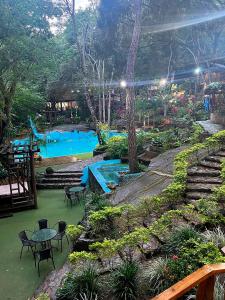 a swimming pool with tables and chairs in a park at Hotel Cabañas Club Sierra Limón in Santa Marta