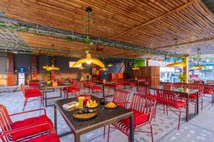 um restaurante com cadeiras e mesas vermelhas e mesa de cabeceira em The Hosteller Rishikesh, Ganges em Rishikesh