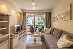 a living room with a couch and a television at City Center Apartment in Marbella in Marbella