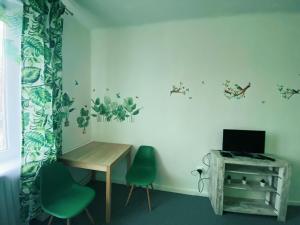 Habitación con mesa, 2 sillas y escritorio. en Jungle Rooms, en Gdansk