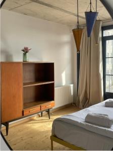 um quarto com uma cama e uma cómoda em madeira em Black Tomato Hostel Kutaisi em Kutaisi